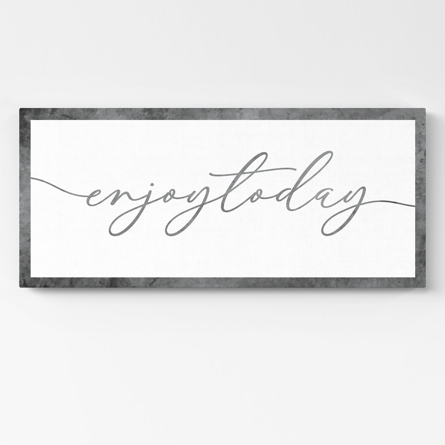 Quadro moderno con scritta "Enjoy Today" in calligrafia elegante su fondo bianco e cornice antracite stampata su tela – decorazione motivazionale da parete per casa o ufficio.