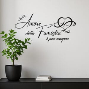 Scritta adesiva da parete famiglia in vinile nero con frase “L’amore della famiglia è per sempre”, applicata su muro bianco in soggiorno moderno.