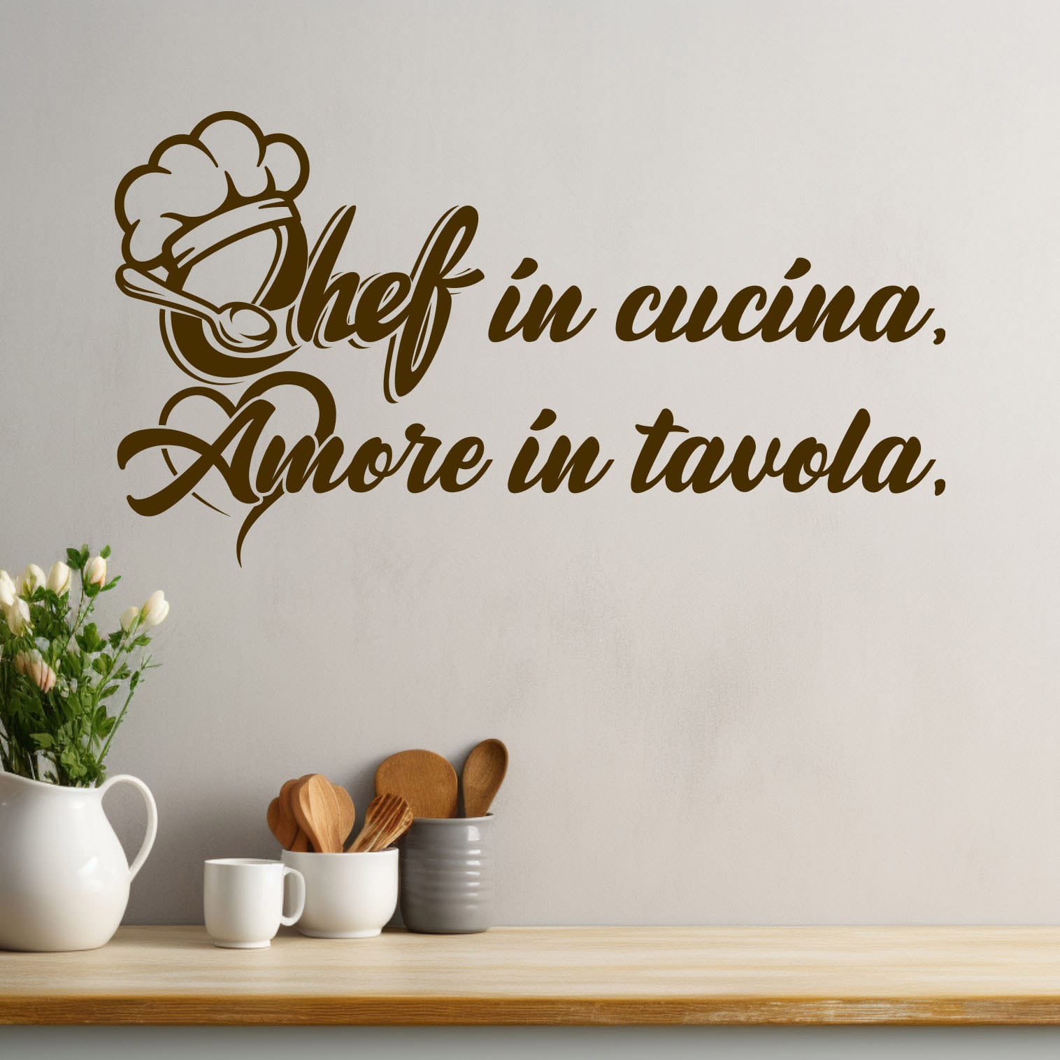 Adesivi murali con frasi per cucina "Chef in cucina, Amore in tavola" su parete moderna con utensili da cucina in legno.