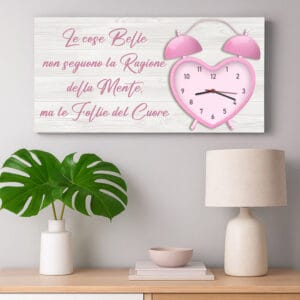 Orologio a muro con frase su tela romantica in stile moderno appeso sopra un mobile con decorazioni minimal.