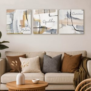 Tris di quadri astratti con scritte su tela 50x50 cm appesi sopra un divano moderno in un soggiorno elegante.