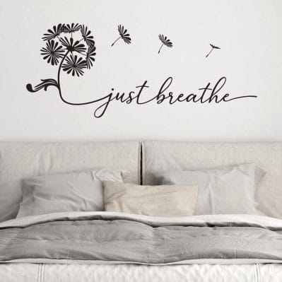 Sticker da parete camera da letto con scritta “just breathe” in vinile nero e soffione decorativo.