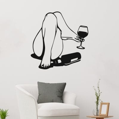 Adesivo da parete arte moderna nero con figura stilizzata femminile e bicchiere di vino, su parete bianca in soggiorno moderno.