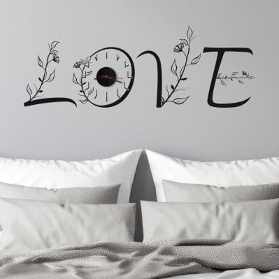 Orologio per parete con sticker love nero sopra letto matrimoniale