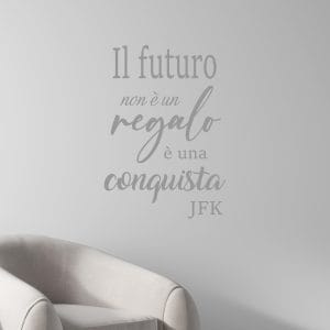 Adesivo da parete citazione motivazionale Il futuro non è un regalo è una conquista JFK in colore argento opaco applicato su parete moderna elegante.