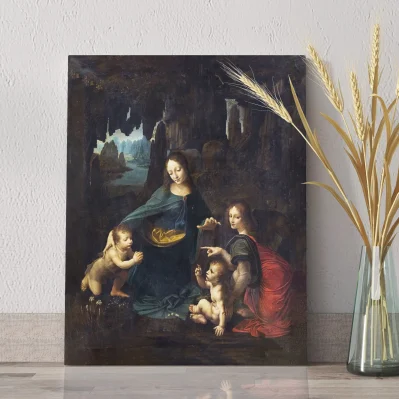 Quadro Vergine delle Rocce Leonardo da Vinci appoggiato su piano chiaro con vaso decorativo.